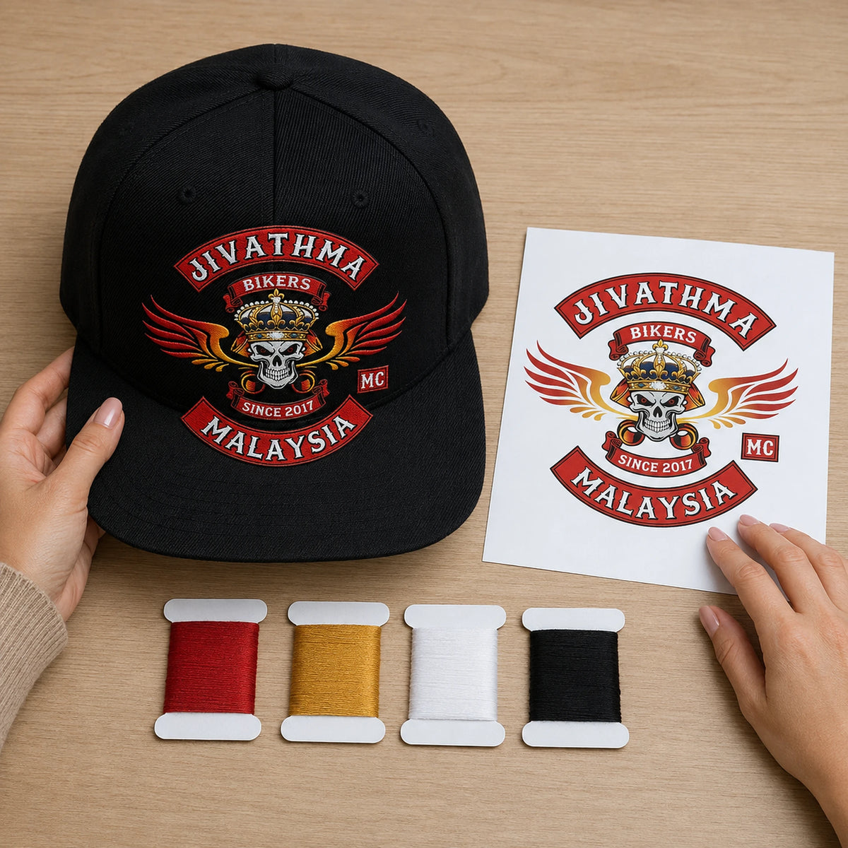 A designer prepares a motorcycle club flat-brim cap layout using the approved emblem reference.
