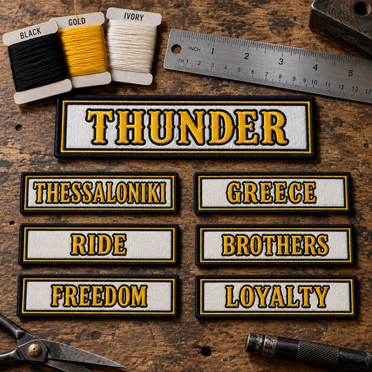 Name-bar samples beside thread cards, a ruler and lettering proofs on an inspection table, with no hands or people, showing custom motorcycle club name bar patch options.