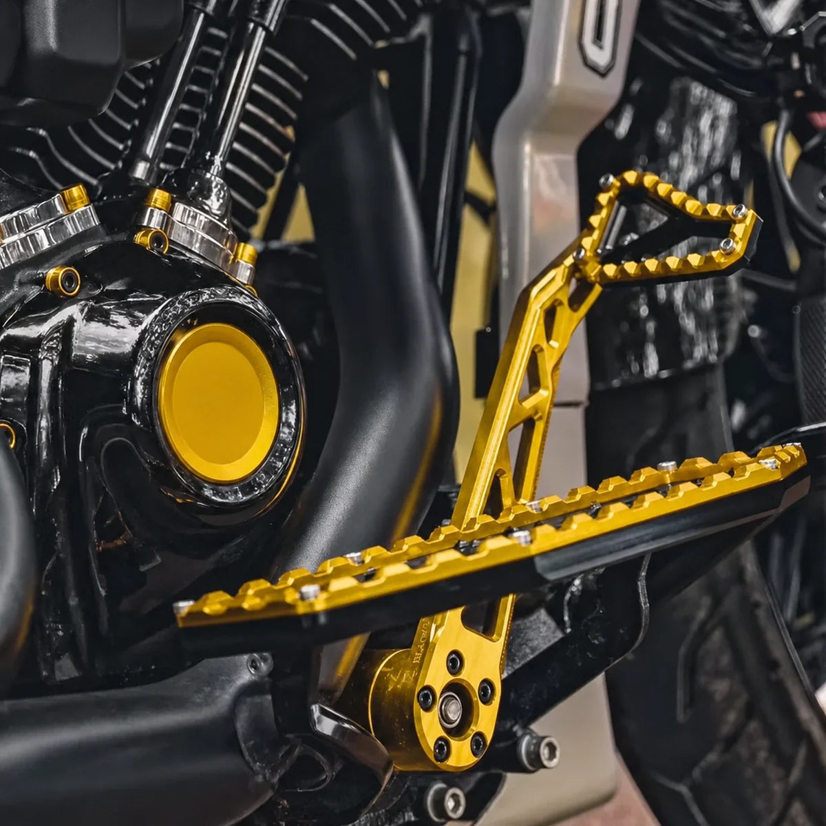 Gold and black PB-style brake pedal installed with matching motorcycle foot controls