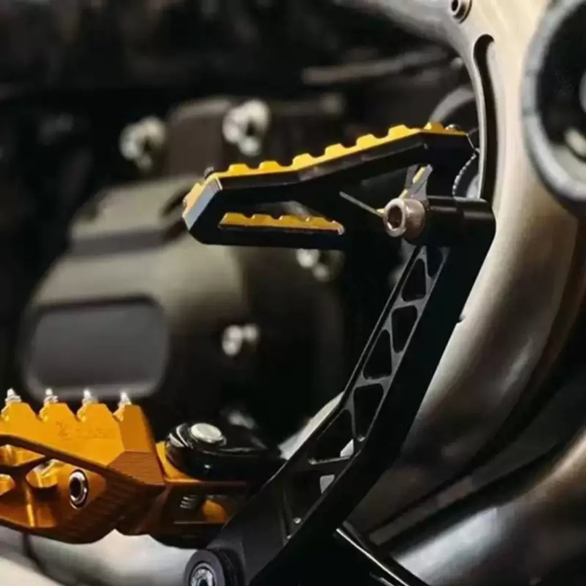 Gold and black PB-style brake pedal installed on a compatible Harley motorcycle