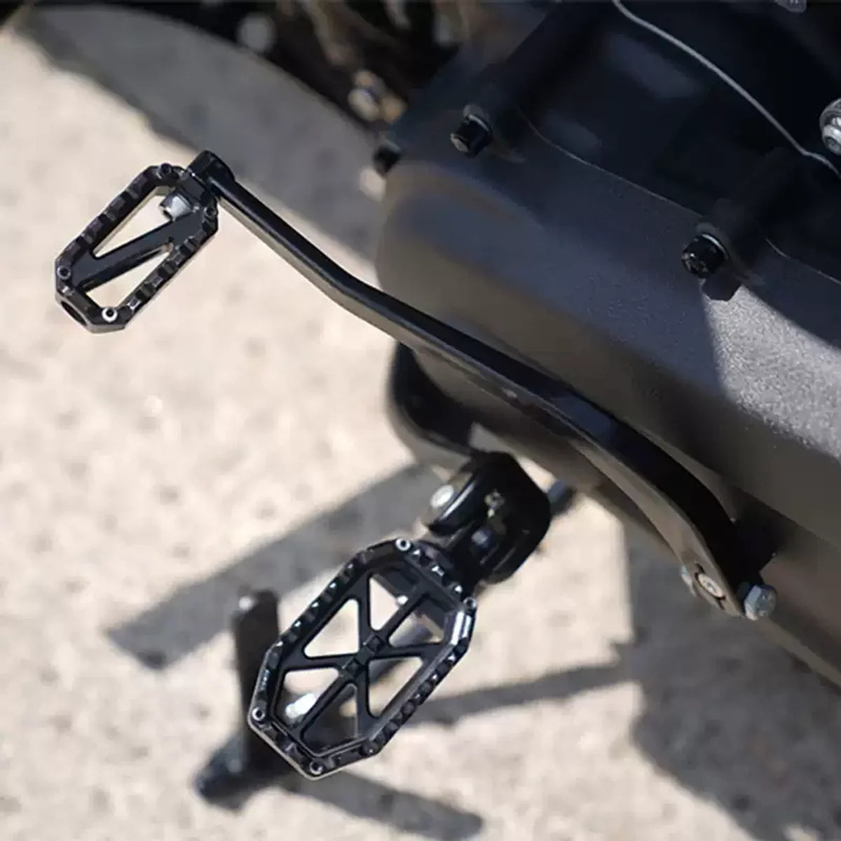 Black PB-style rear foot peg installed on a Harley motorcycle