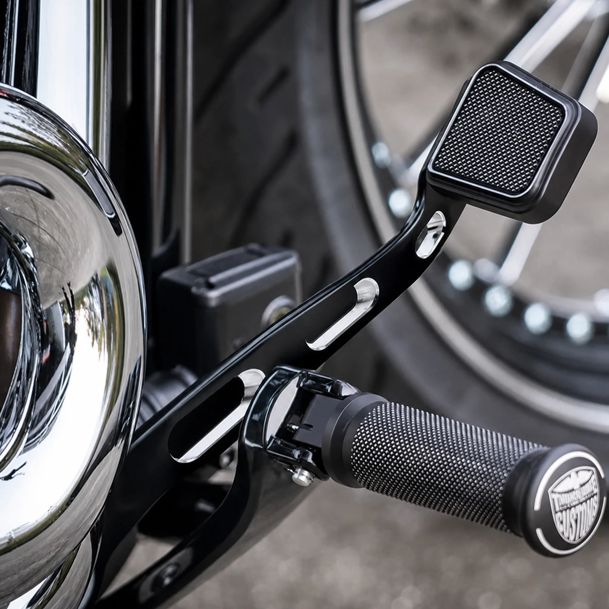 Close-up of machined Harley Softail forward-control brake lever and pedal pad