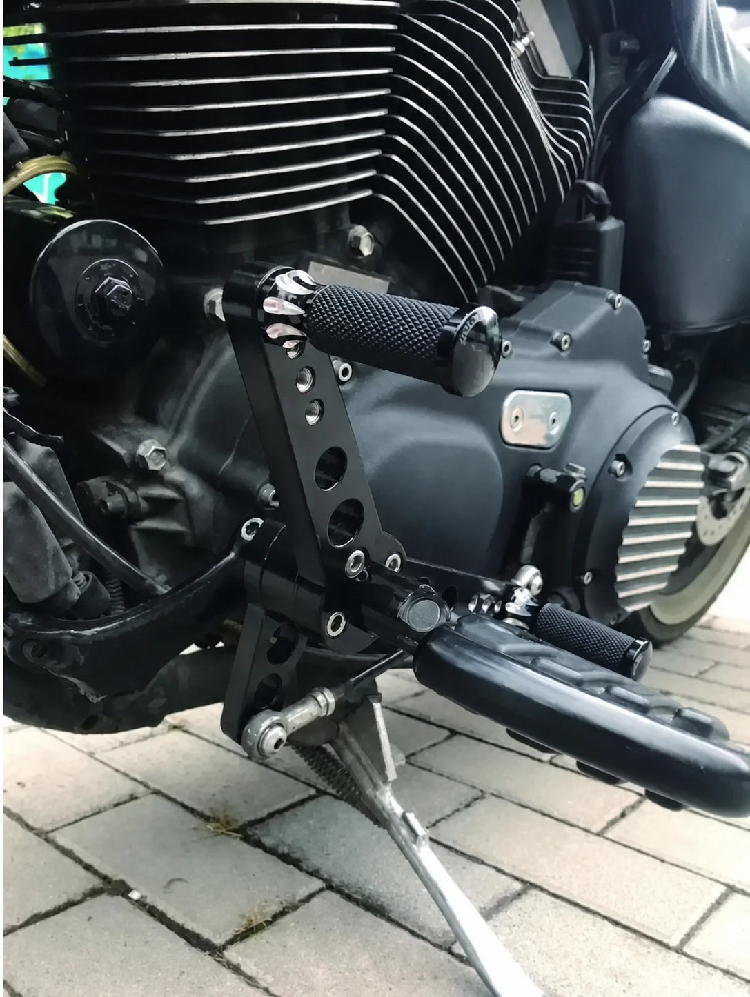 Close view of Harley Sportster forward shift bracket and foot peg