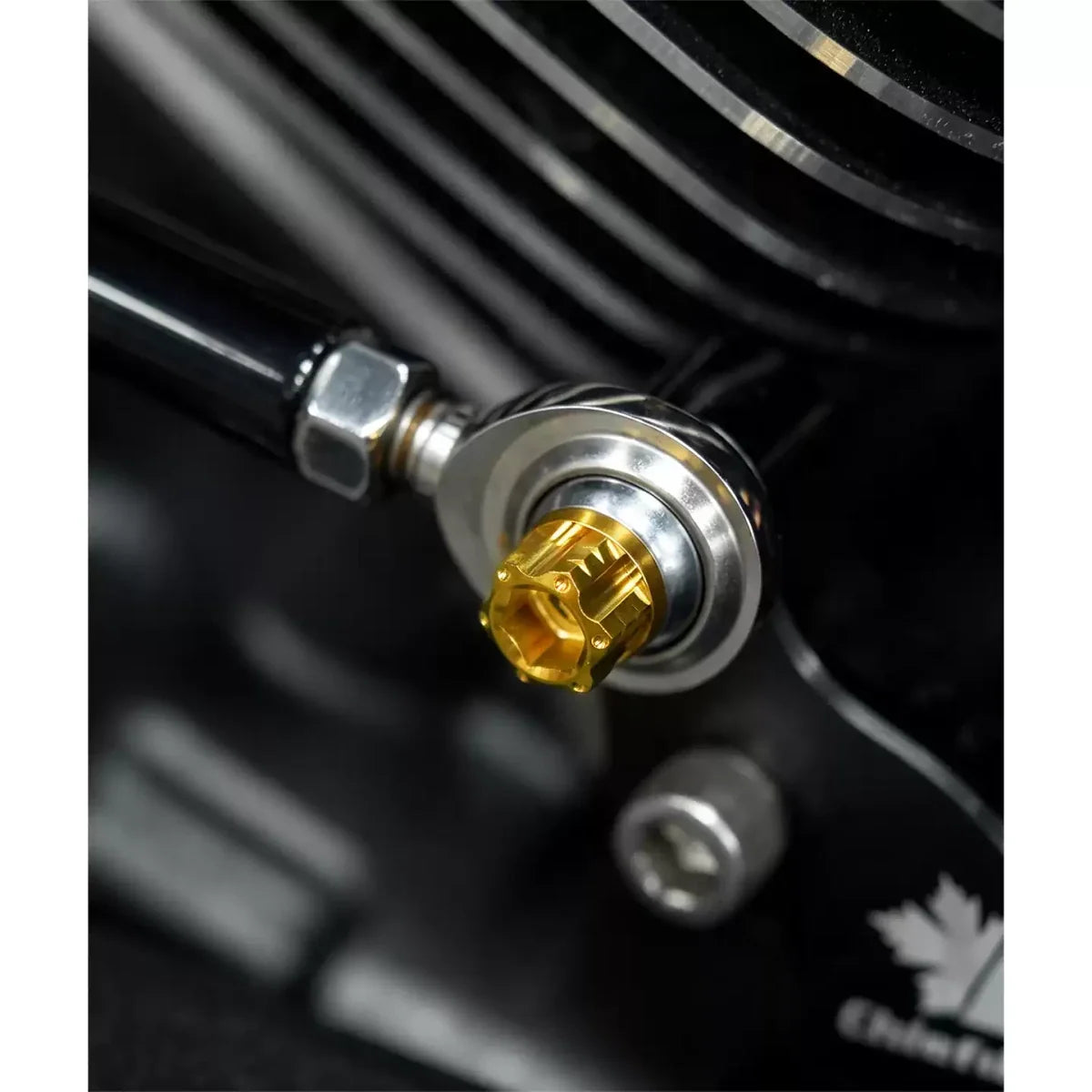 Gold titanium Harley foot-control bolt installed close-up