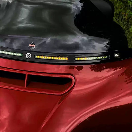 LED windshield trim running and turn signal lights installed on a red Harley Touring motorcycle