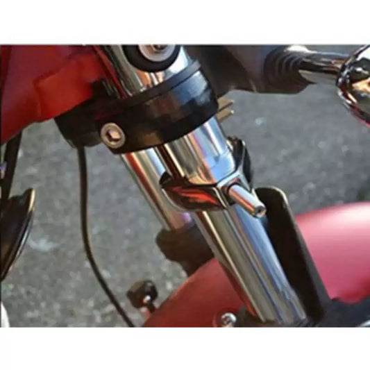 Chrome turn signal relocation bracket installed on a Harley motorcycle front fork