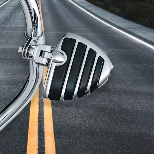 Kuryakyn chrome and black highway foot peg installed on a Harley engine guard