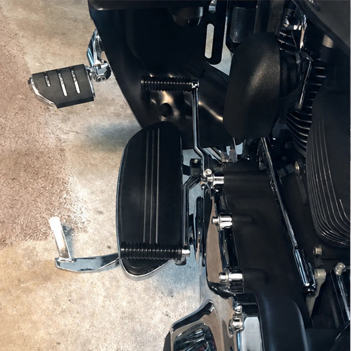Extended black shift peg installed on a Harley touring motorcycle