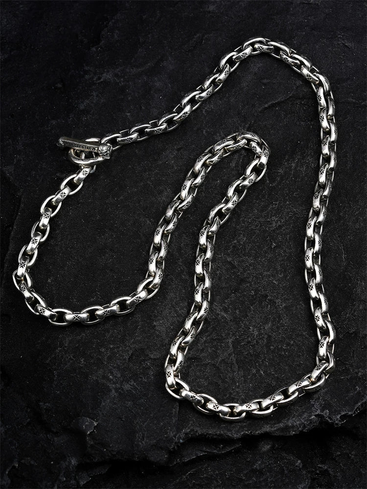 Maltese cross link sterling silver biker necklace laid flat on black stone