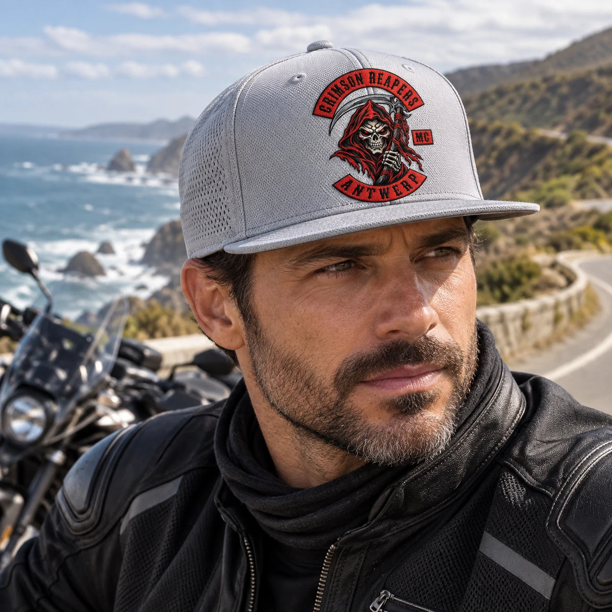 Un motociclista de un club de motocicletas usa una gorra de poliéster técnico gris hielo de ala plana en una parada costera.