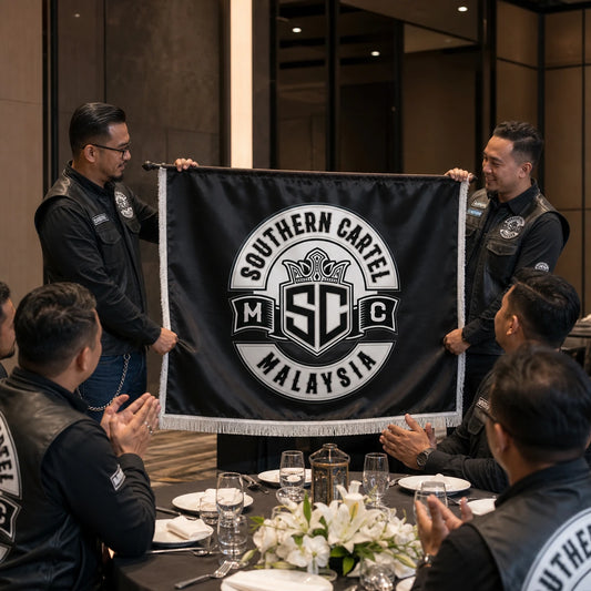 A club president presents a fringed custom anniversary flag during a motorcycle chapter celebration.