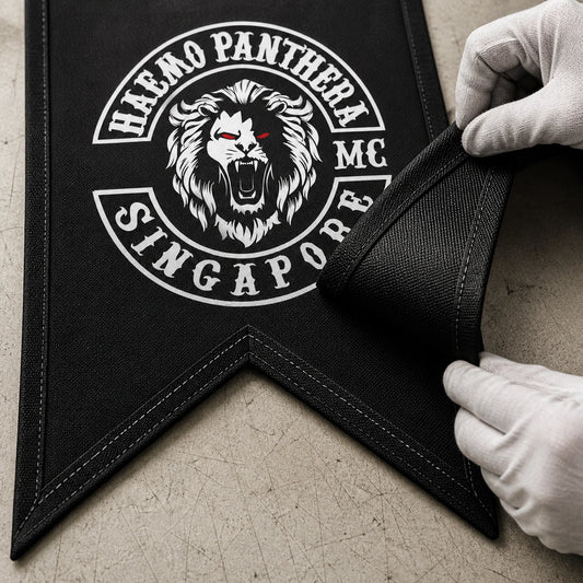 Close inspection of durable fabric, binding and stitching on a custom motorcycle club swallowtail flag.