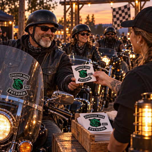 Adult motorcycle club riders receiving commemorative custom stickers at an evening anniversary ride finish checkpoint.