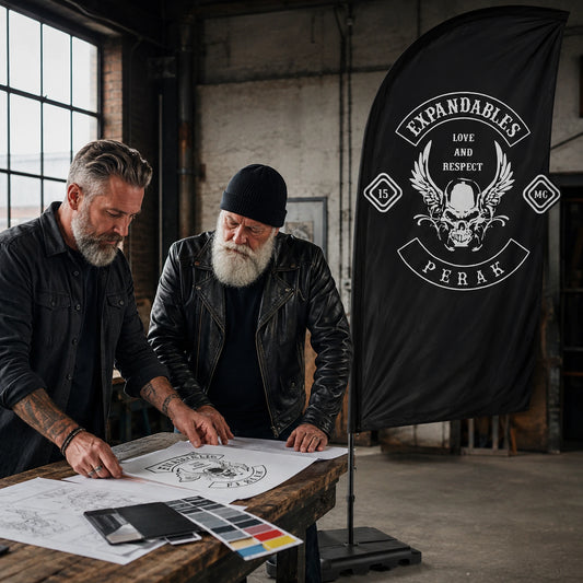 Custom Artwork Design: custom motorcycle club feather flag shown in designer and mature rider working at an industrial studio table.