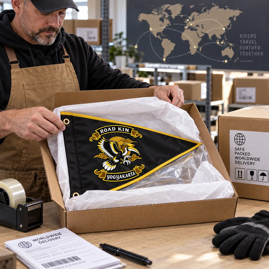 A fulfillment specialist securely packs a finished custom motorcycle club triangle flag for worldwide shipping.