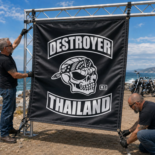 Event crew securing a heavy-duty custom motorcycle club banner at a windy coastal rally.