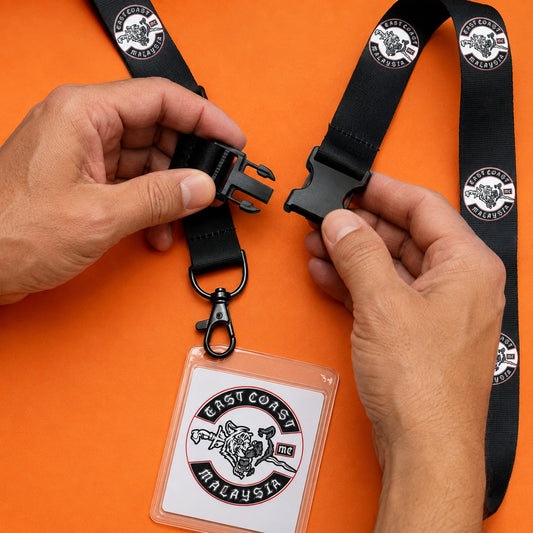 Separated halves of a detachable buckle linking a club-logo neck strap to its credential assembly.