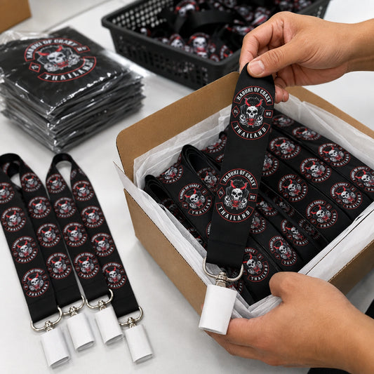 Hands arranging completed motorcycle club lanyards in a plain carton for order packing.