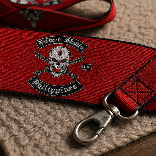 Close-up of a woven motorcycle club lanyard showing colored threads, the club emblem and a J-hook.