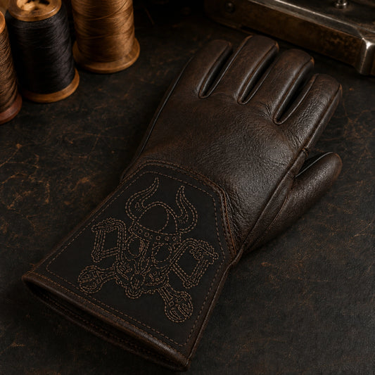 A brown gauntlet motorcycle club glove shows sparse monochrome contour stitching on a thin supported cuff patch.