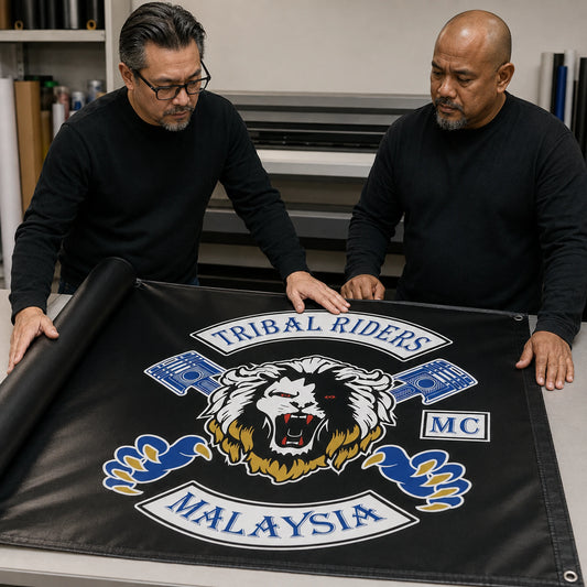 A club representative reviewing authorized logo artwork on a custom motorcycle event banner.