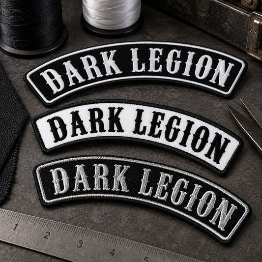 Small thread cards and embroidered name-bar samples arranged for color matching under neutral inspection lighting, products dominant and no logo reference visible, showing custom motorcycle club name bar patch options.