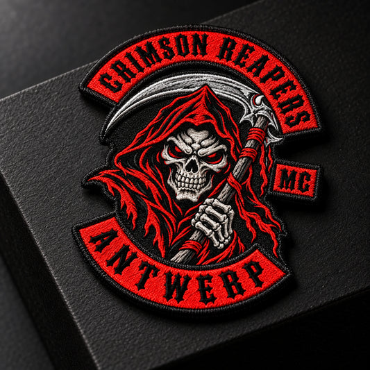 Compact original wing-and-wheel style emblem patch for a motorcycle club, shown at matte black product plinth.