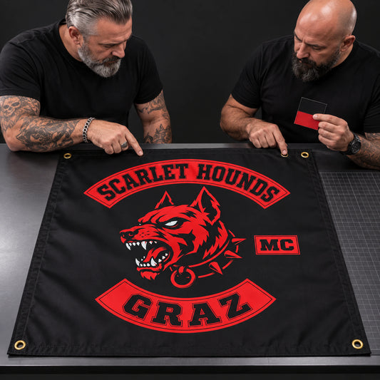 Two motorcycle club officers inspect the Scarlet Hounds square flag proof before production.