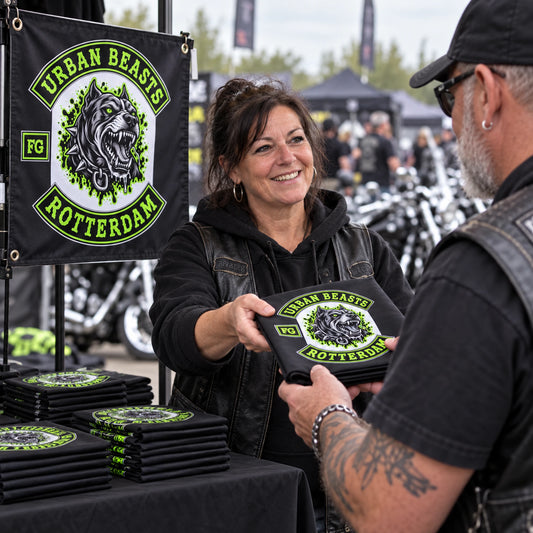 A rally volunteer hands a collectible Urban Beasts square club flag to a motorcycle club supporter.