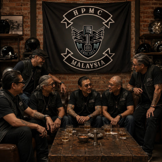 Motorcycle club members gather beneath a custom hanging flag in a warm brick clubhouse lounge.
