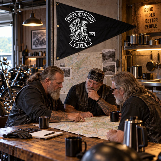 Motorcycle club members gather beneath a custom triangle flag in a warm brick clubhouse.