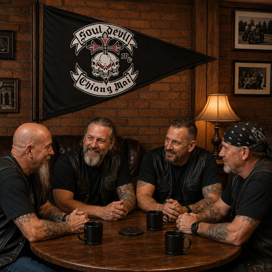 Motorcycle club members gather beneath a custom triangle flag in a warm brick clubhouse.