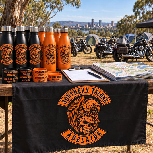registration table at an outdoor motorcycle rally with logo bottle merchandise, no humans for a motorcycle club.