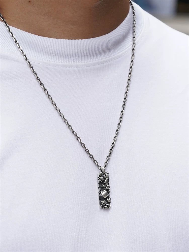 Multi-skull sterling silver biker pendant worn on a chain for scale