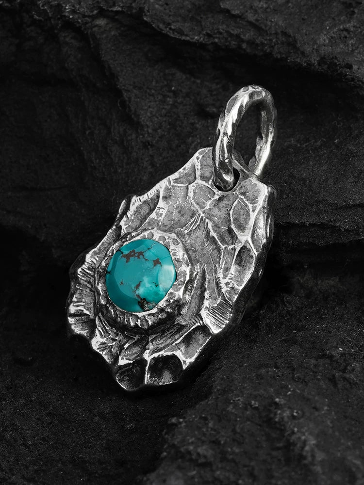 Angled view of turquoise set in textured sterling silver pendant