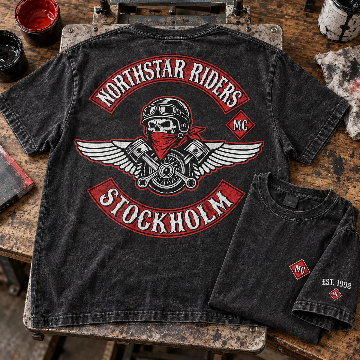 Northstar Riders Stockholm washed-black club T-shirt with distressed fabric texture and a small EST. 1998 sleeve print in a screen-print workshop.