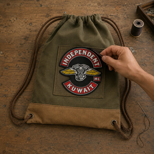 A motorcycle club patch is positioned on a rugged canvas drawstring bag.