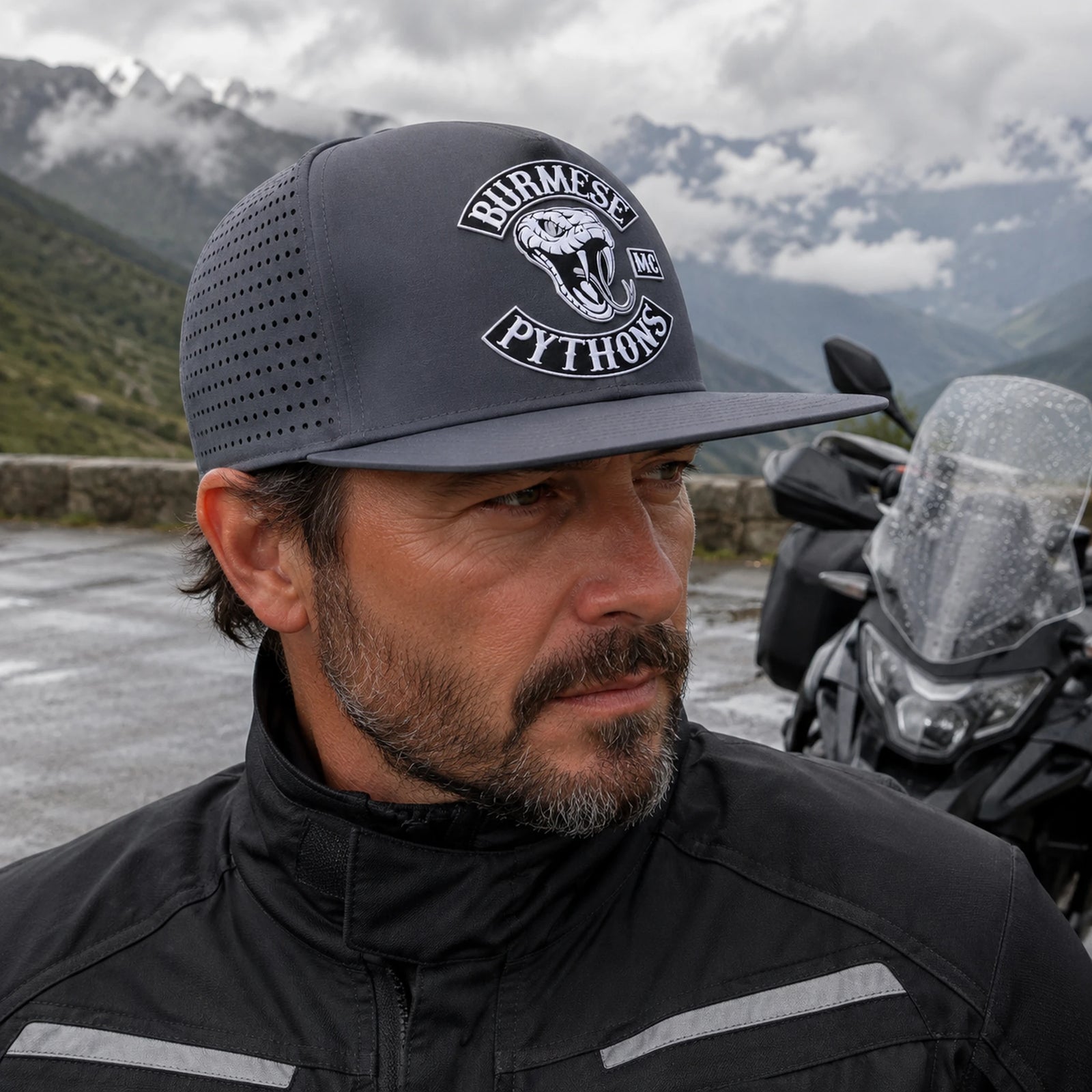 A touring motorcycle club rider wears a lightweight charcoal performance flat-brim cap.