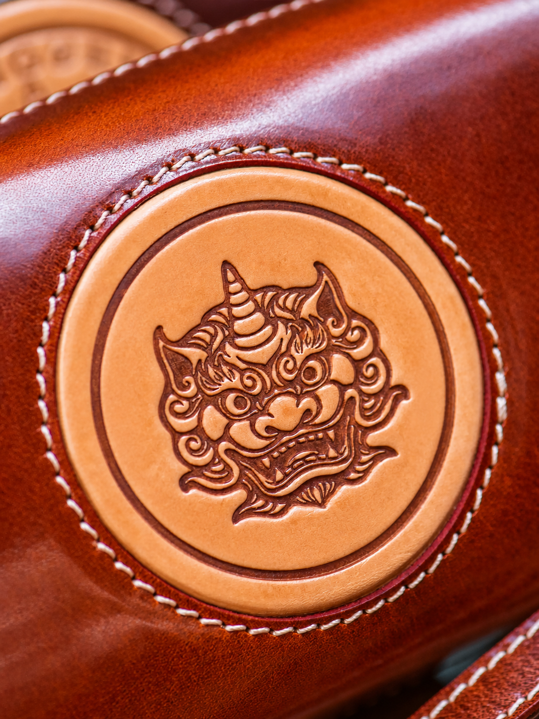 hand-tooled Pixiu leather medallion detail without supplier branding