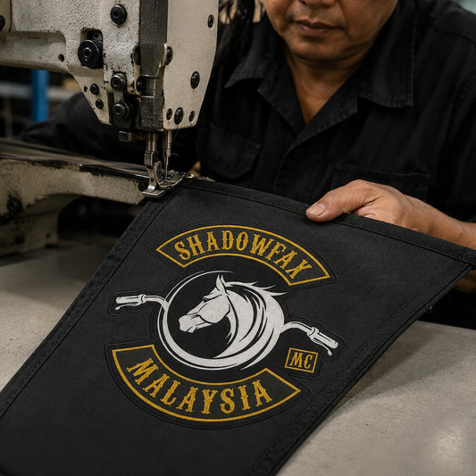 An experienced sewing operator finishes the reinforced edge of a custom motorcycle club triangle flag.