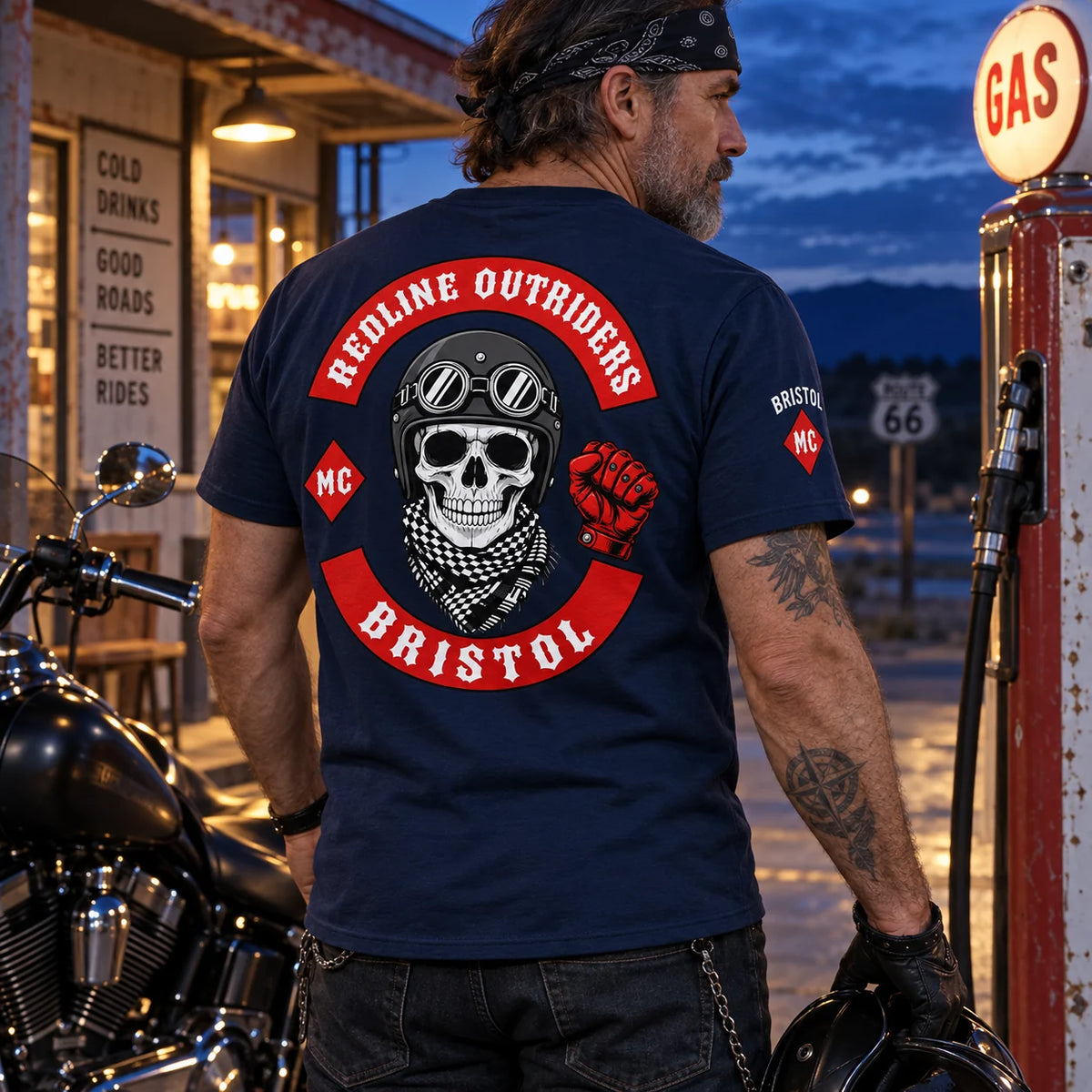 Redline Outriders Bristol rider wearing a dark navy club T-shirt with a compact Bristol MC sleeve mark at a vintage gas station after sunset.