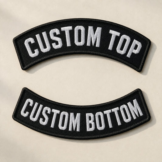 Custom motorcycle club classic arc rocker pair with a traditional embroidered curve on a neutral tabletop.