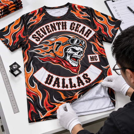 Technician inspecting a Seventh Gear Dallas full-coverage motorcycle club performance shirt sample and its white interior.