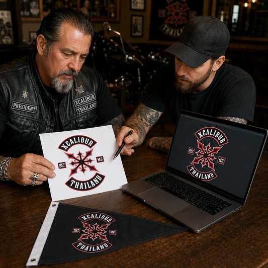 A motorcycle club president shares approved logo artwork with a designer at a clubhouse table.