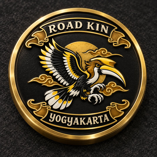 Round antique-gold metal ROAD KIN medallion pin with a sculpted hornbill and fully visible circular rim on dark felt.