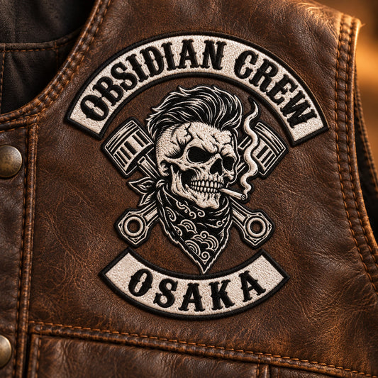 Structured shield emblem chest patch for a motorcycle club, shown at brown leather vest panel.