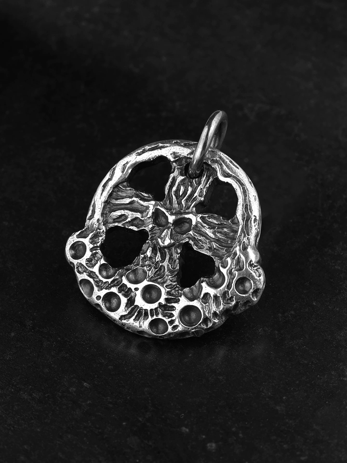 Angled view of skull cross moon silver pendant