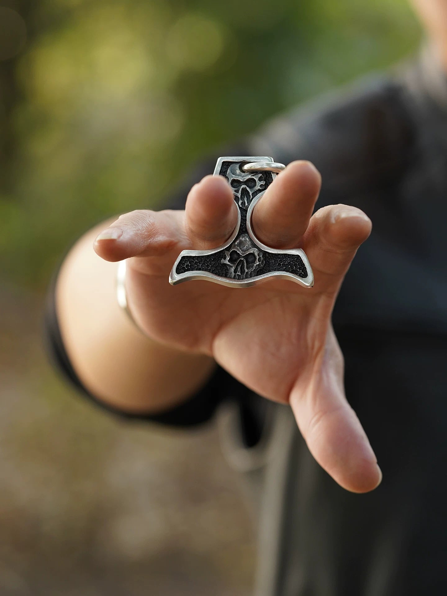 Skull knuckle duster sterling silver pendant shown in hand for scale