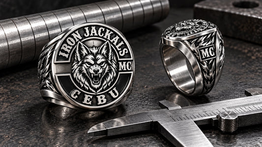 Wide-band stainless steel club ring shown from the front and side beside sizing tools.