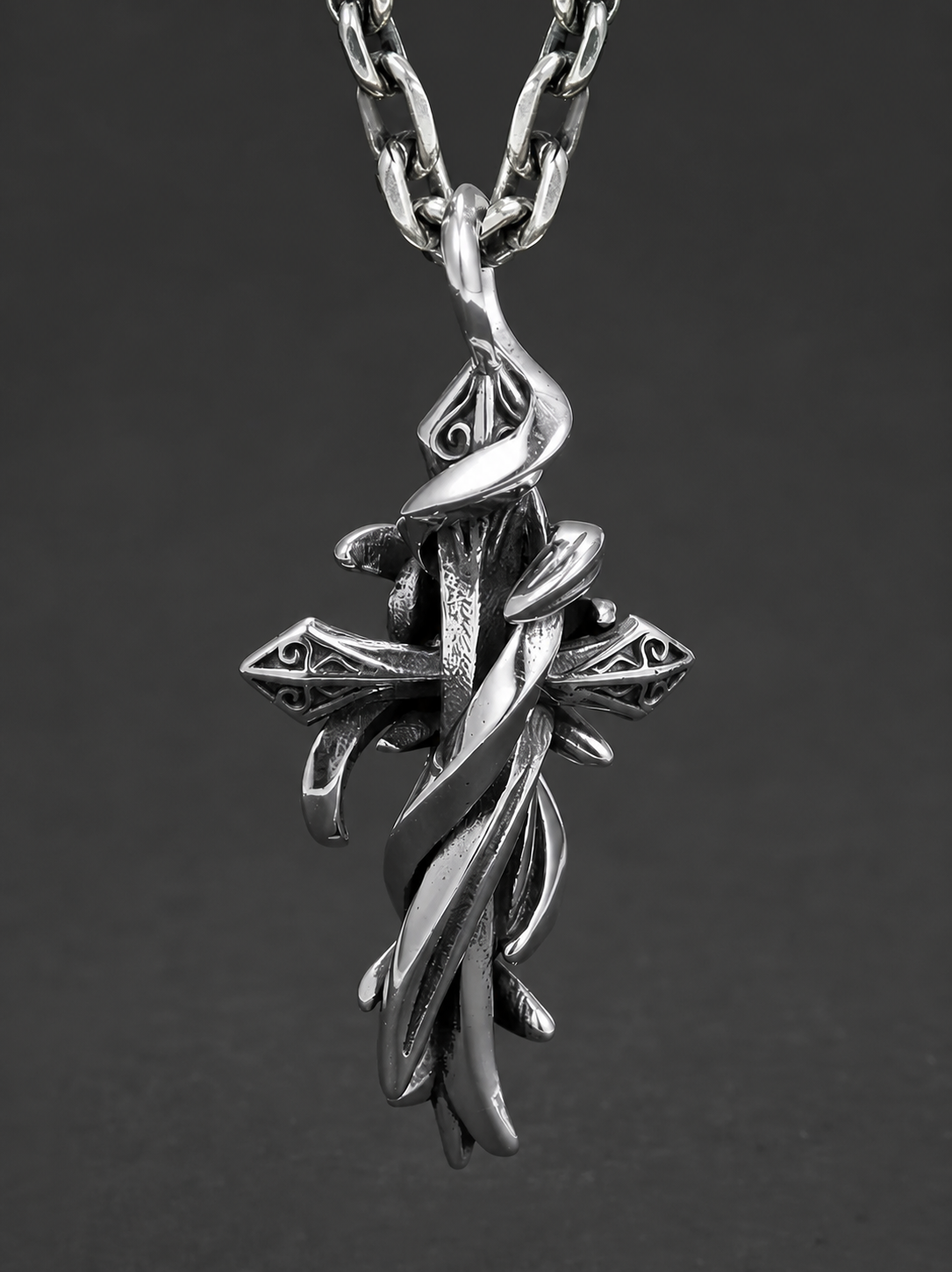 Thorn wrapped vintage cross sterling silver biker pendant on dark background